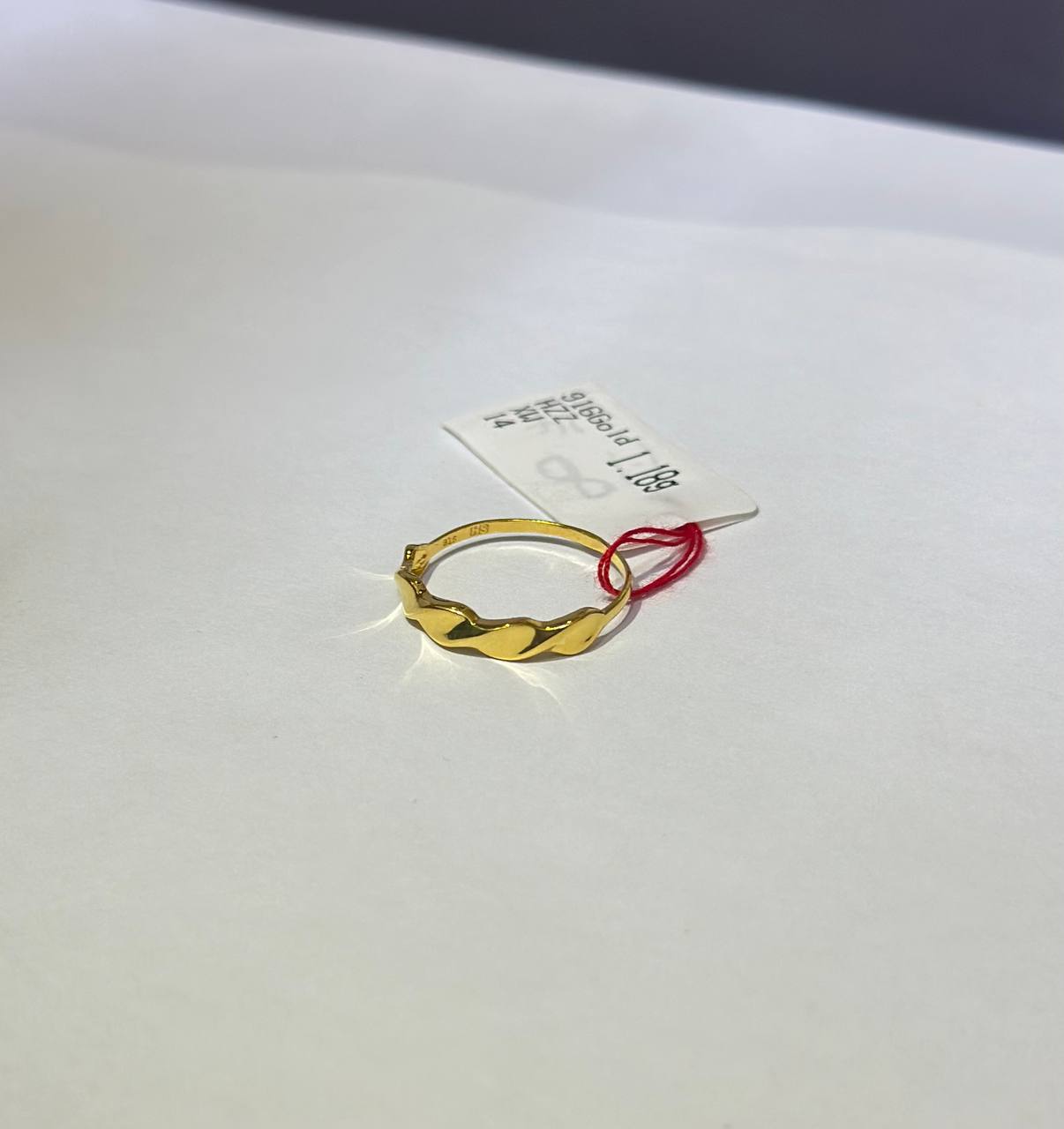 "Gold hoop mobius ring on a white card with text"