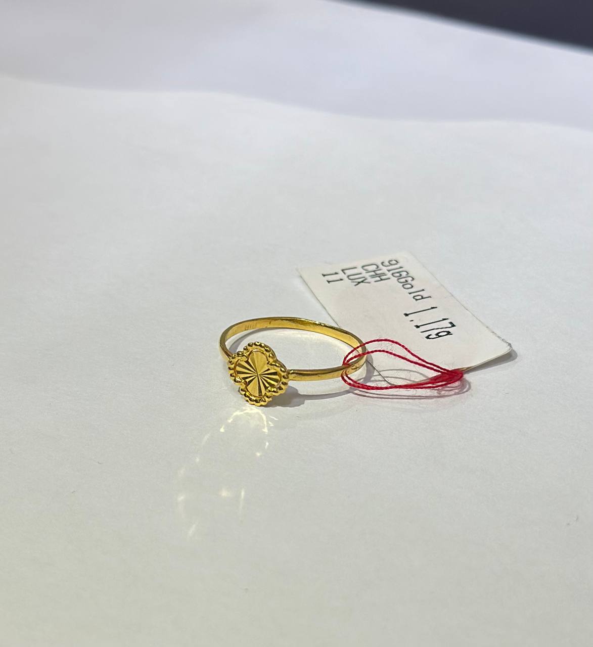 "Gold ring with a decorative design on a white background"