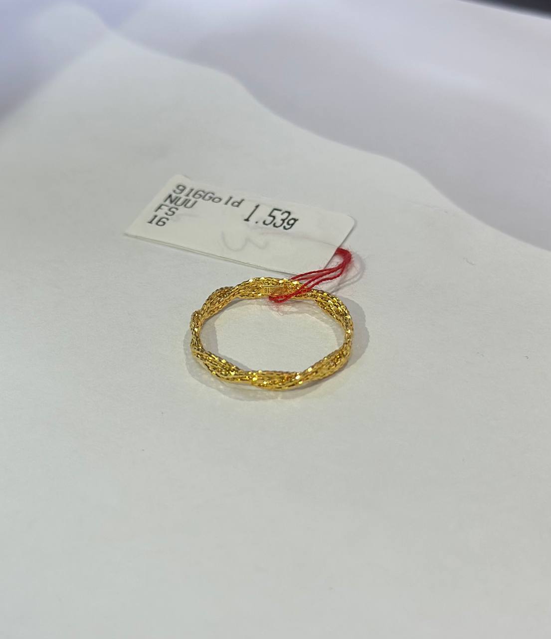 "Filigree 916 gold ring with a tag displaying weight on a white background"