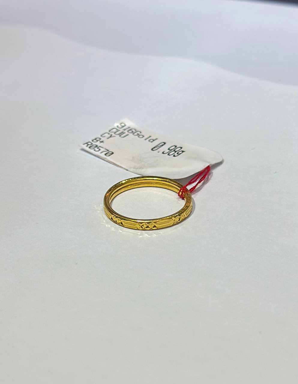 "Gold ring on a white background with a label"