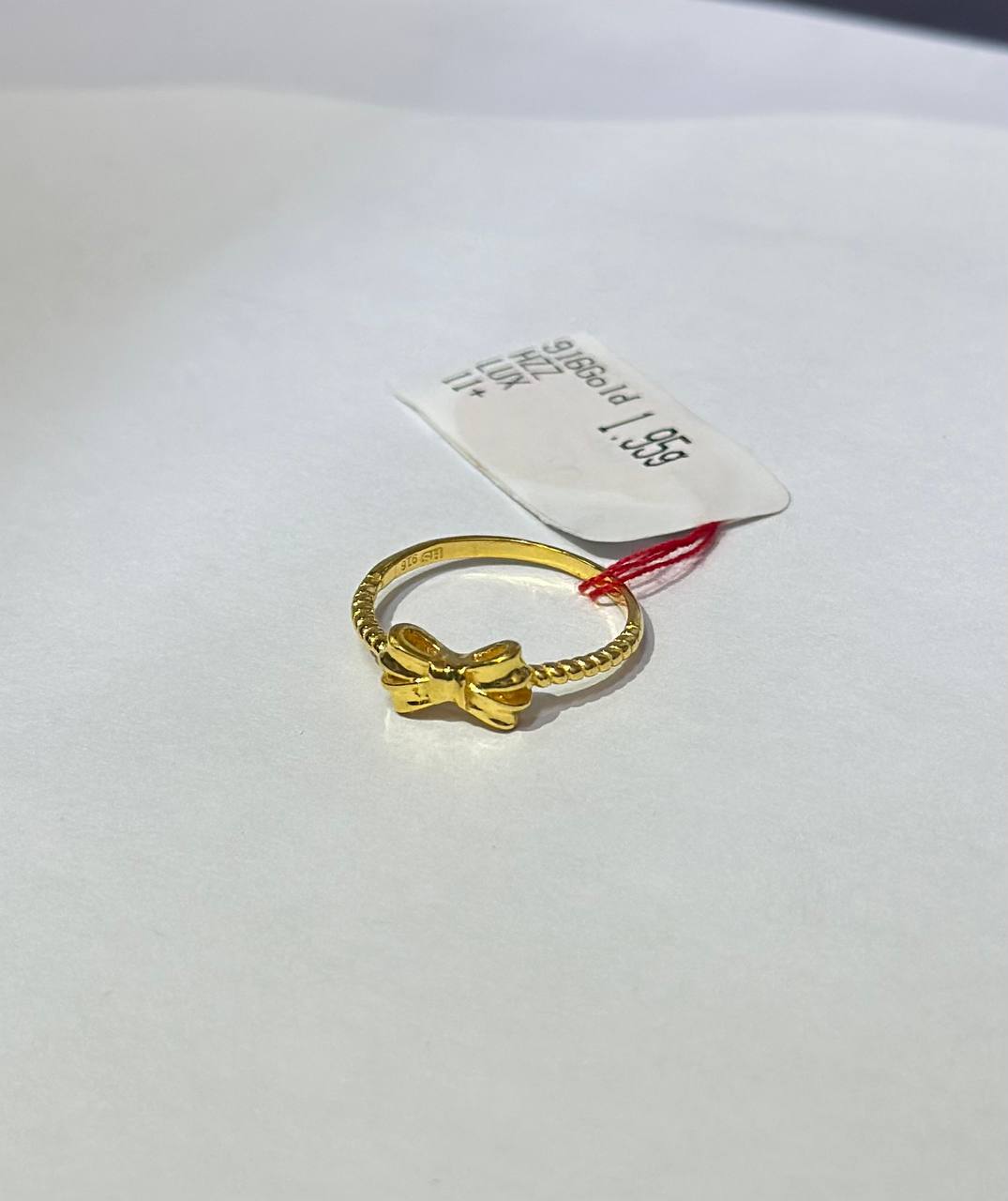 "Gold ring with ribbon design on a white background"