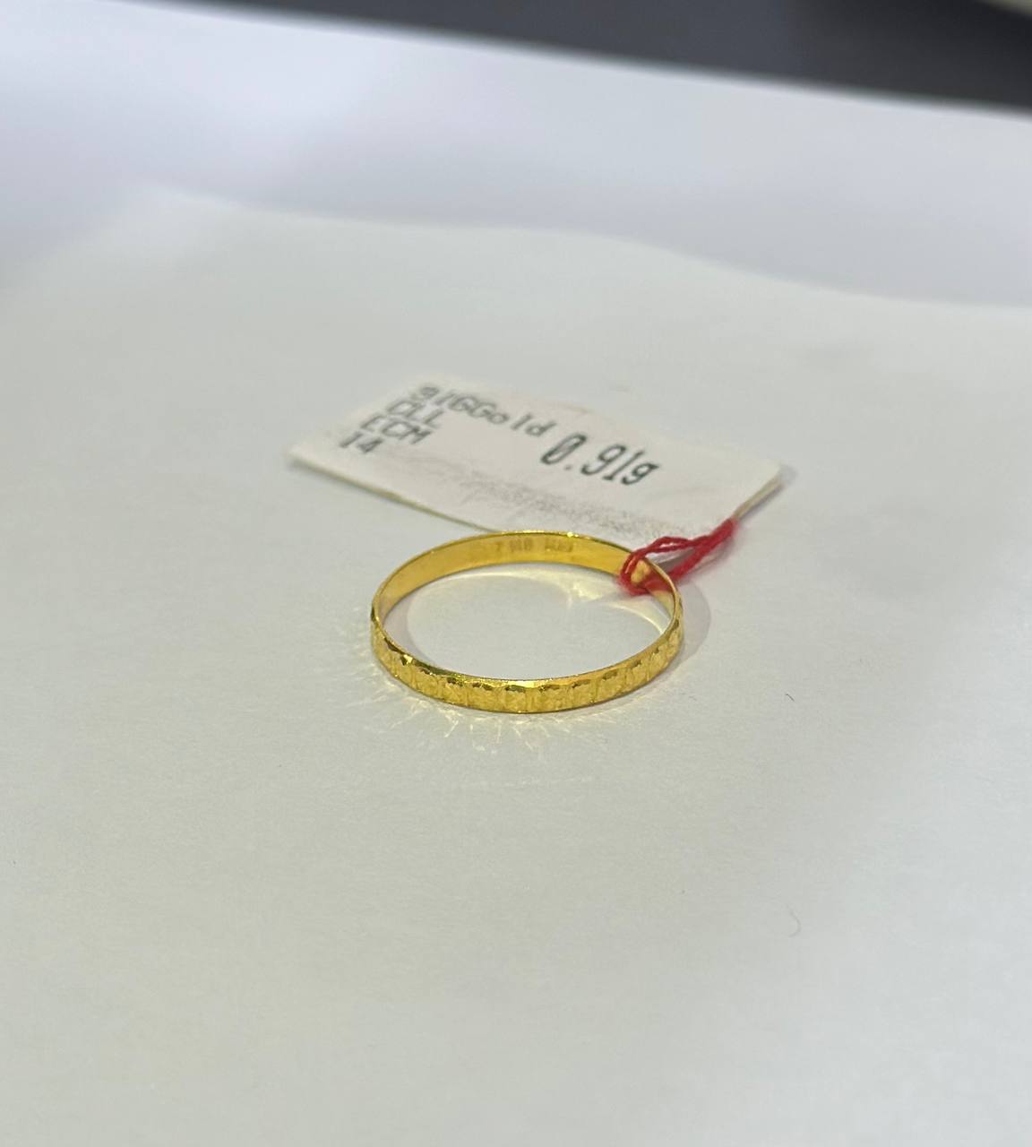 "Gold ring with a tag on a white background"
