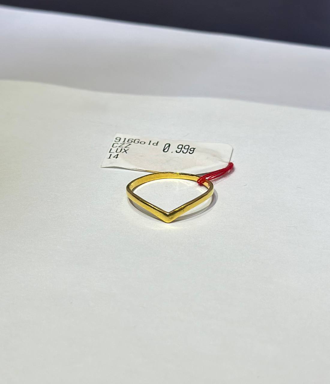 "Gold ring design V with a red accent on a white background"