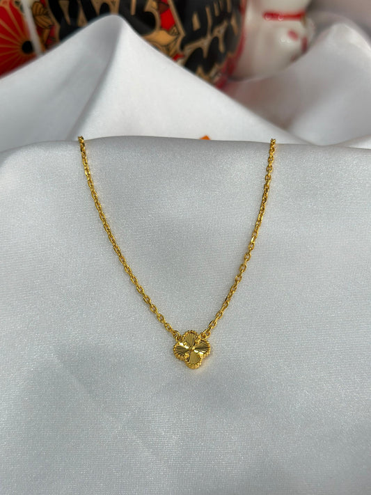 “22K gold flower necklace featuring a delicate four-leaf clover design by Kedai Emas Hua Shing, symbolizing luck and elegance, perfect for special occasions.“
