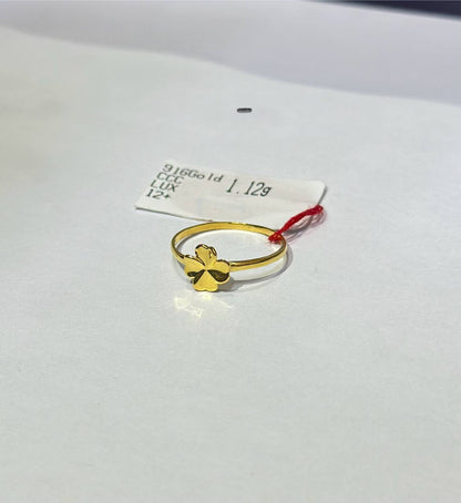 "Gold ring with a four-leaf clover design on a white background"