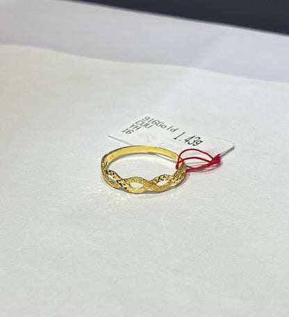 "Gold ring on a white card with text"